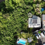 Installation de panneaux solaires en autoconsommation à La Réunion par Solar Service. Client content devant sa maison et sa piscine.