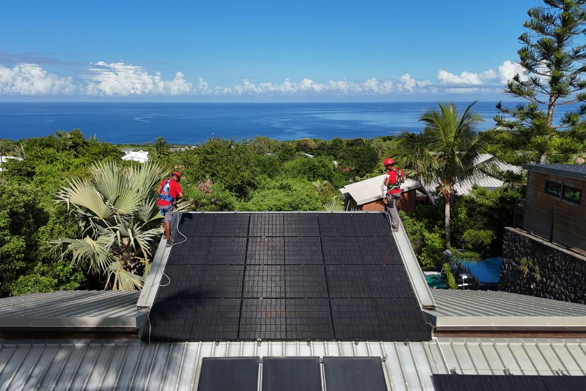 Techniciens posant des panneaux solaires à La Réunion sur toiture en tôle