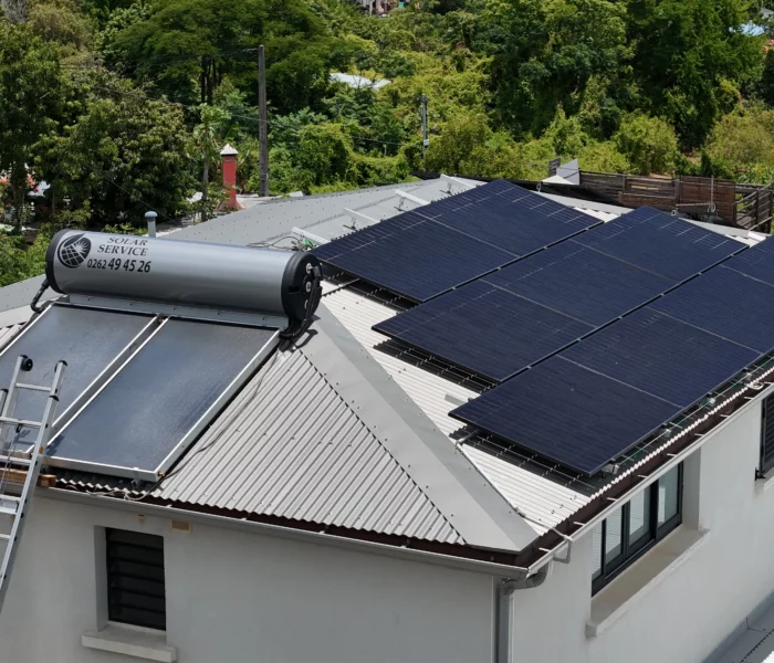 Exemple de différence sur un toit à La Réunion entre un panneau solaire pour l'eau chaude et des panneaux photovoltaïques