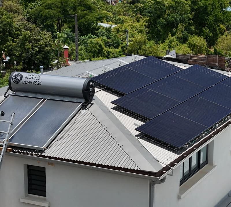 Exemple de différence sur un toit à La Réunion entre un panneau solaire pour l'eau chaude et des panneaux photovoltaïques