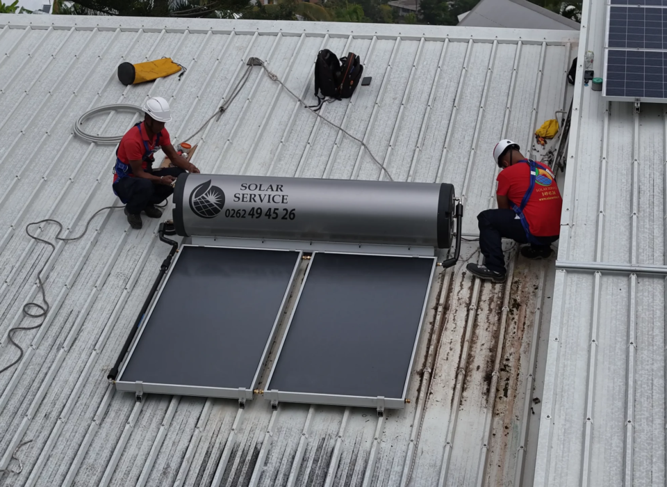 Technicien vérifiant l'installation d'un chauffe-eau solaire à La Réunion