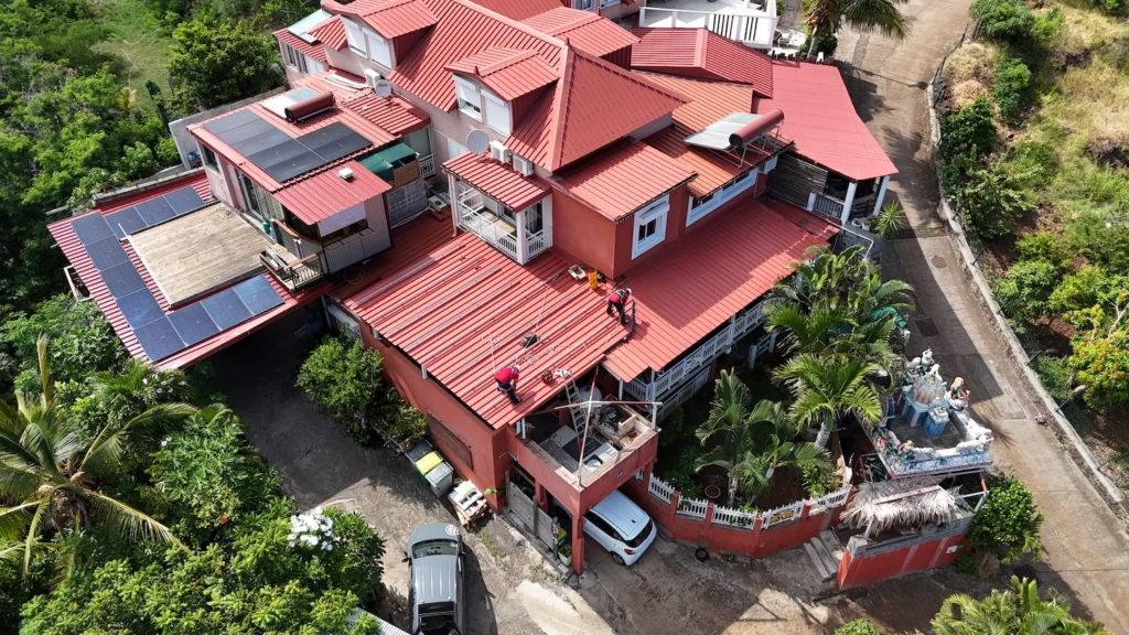 Vue aérienne d'une centrale photovoltaïque 9 kWc répartie sur plusieurs pans de toiture à Saint-Leu.