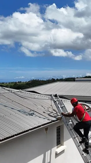 Techniciens Solar Service installant des panneaux solaires et un chauffe-eau solaire sur une toiture à La Réunion
