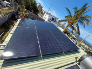 Panneaux solaires photovoltaïques installés sur une toiture à La Réunion avec vue sur l’océan