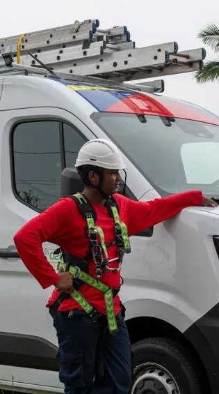 Technicien Solar Service équipé d’un harnais de sécurité devant le véhicule d’intervention photovoltaïque à La Réunion
