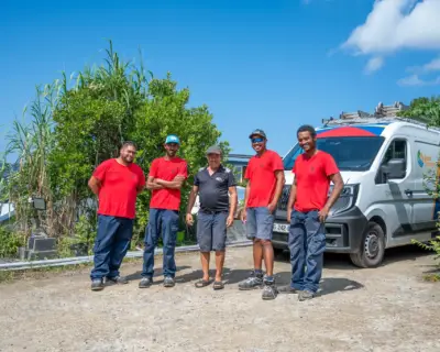 Équipe de techniciens Solar Service en tenue rouge devant leur véhicule d'intervention, spécialistes du dépannage de panneaux photovoltaïques à La Réunion 974