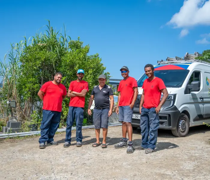Équipe de techniciens Solar Service en tenue rouge devant leur véhicule d'intervention, spécialistes du dépannage de panneaux photovoltaïques à La Réunion 974