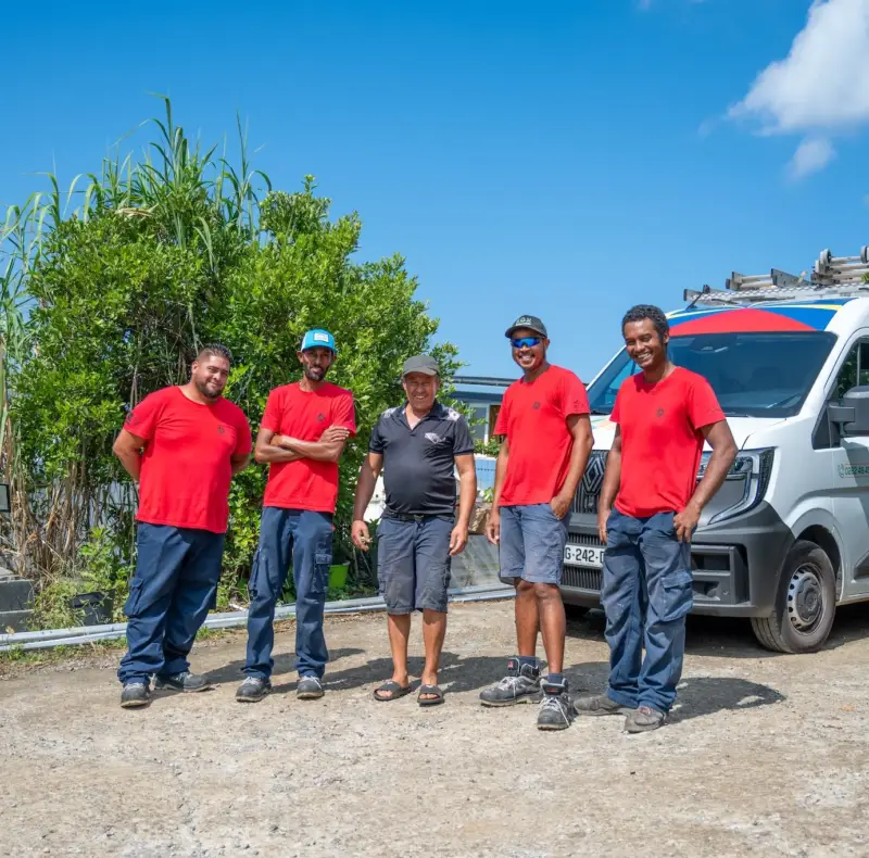 Équipe de techniciens Solar Service en tenue rouge devant leur véhicule d'intervention, spécialistes du dépannage de panneaux photovoltaïques à La Réunion 974