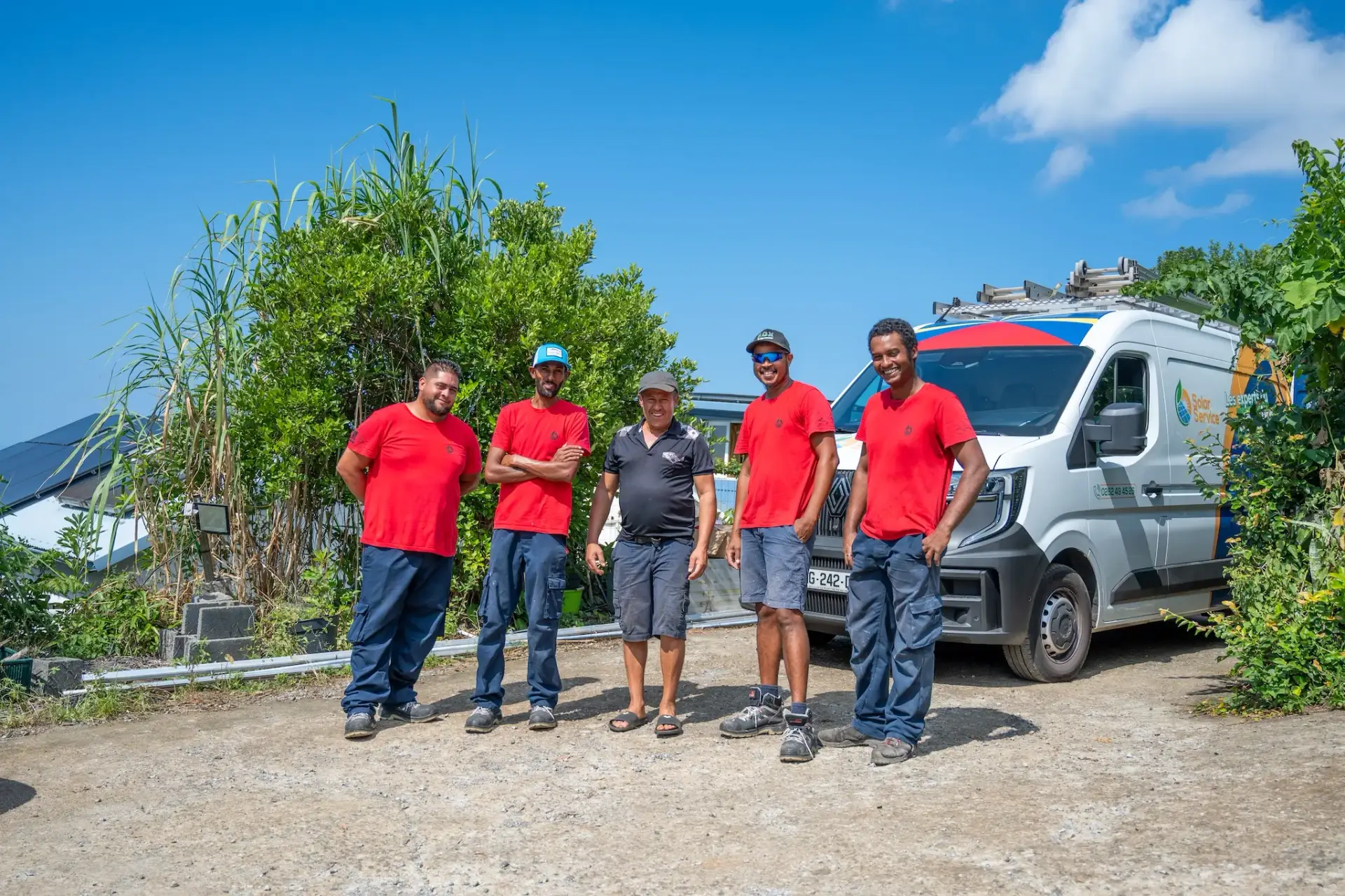 Équipe de techniciens Solar Service en tenue rouge devant leur véhicule d'intervention, spécialistes du dépannage de panneaux photovoltaïques à La Réunion 974