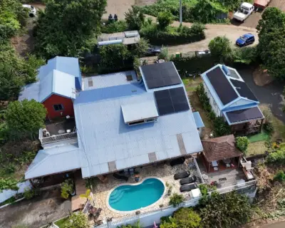 Vue aérienne d'une villa avec piscine et panneaux solaires full black installés par Solar Service à La Réunion