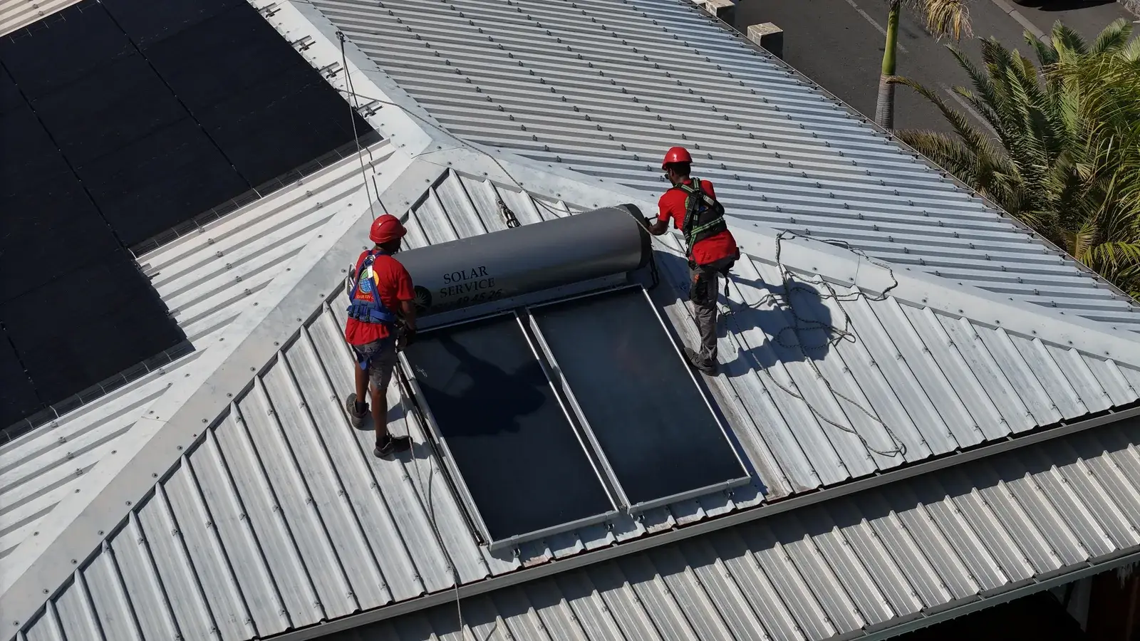 Chauffe-eau solaire et photovoltaïque réunis sur un même toit à La Réunion Vue aérienne d'un chauffe-eau solaire et de panneaux photovoltaïques installés sur la même toiture à La Réunion