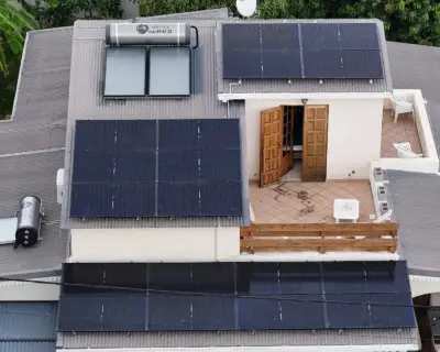 Vue aérienne d'une installation photovoltaïque 9 kWc et deux chauffe-eau solaires sur une maison avec piscine aux Avirons, La Réunion – Solar Service