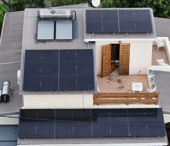 Vue aérienne d'une installation photovoltaïque 9 kWc et deux chauffe-eau solaires sur une maison avec piscine aux Avirons, La Réunion – Solar Service