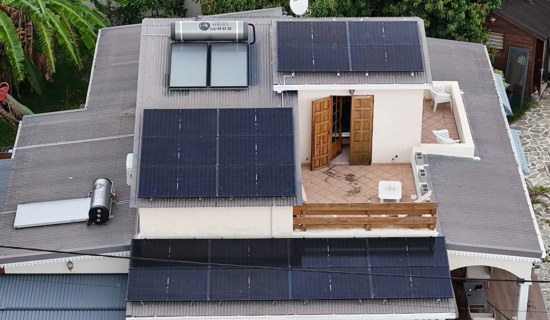 Vue aérienne d'une installation photovoltaïque 9 kWc et deux chauffe-eau solaires sur une maison avec piscine aux Avirons, La Réunion – Solar Service